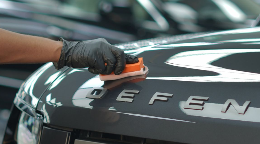 Paint correction being performed on a dark-coloured car panel before ceramic coating